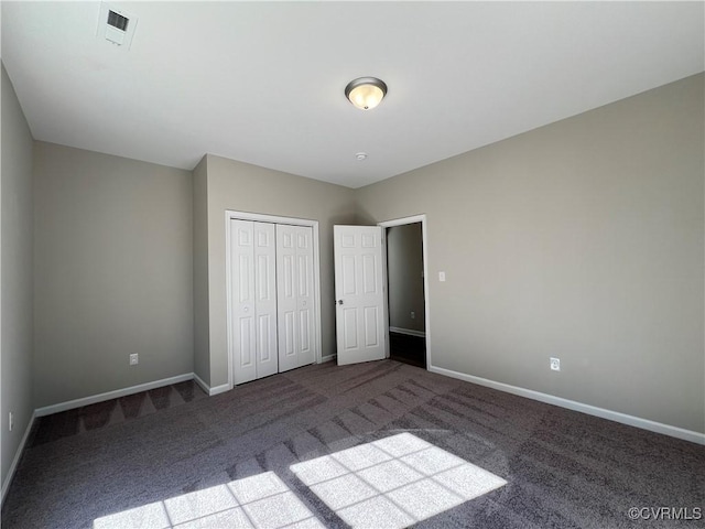 unfurnished bedroom with a closet, carpet flooring, visible vents, and baseboards