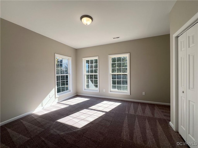 carpeted empty room featuring visible vents and baseboards