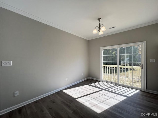 empty room with dark wood-type flooring, a notable chandelier, and ornamental molding