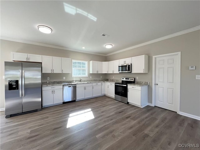 kitchen featuring dark wood-style floors, appliances with stainless steel finishes, crown molding, white cabinetry, and a sink