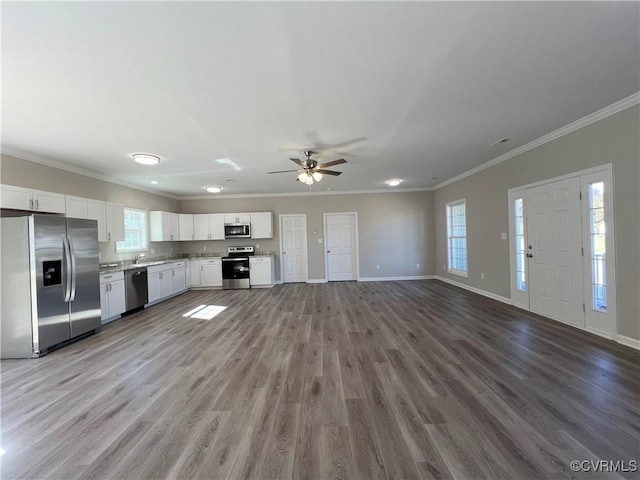 kitchen with stainless steel appliances, white cabinetry, crown molding, and wood finished floors