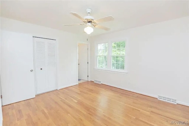 unfurnished bedroom with a ceiling fan, a closet, visible vents, and light wood finished floors