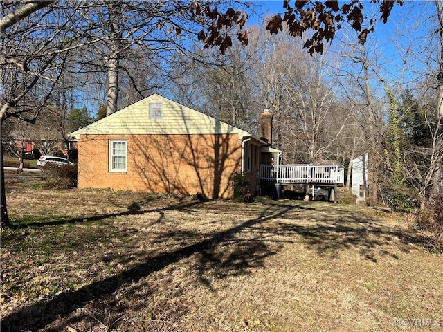 view of home's exterior featuring a chimney and a deck