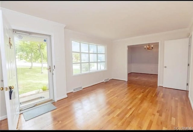 interior space with a chandelier, baseboards, visible vents, and light wood-style floors