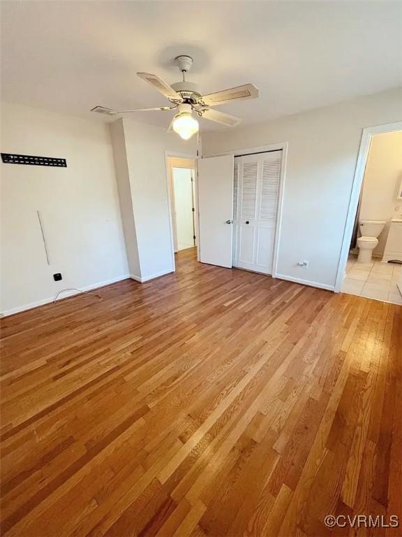 unfurnished bedroom with baseboards, visible vents, a ceiling fan, light wood-type flooring, and a closet