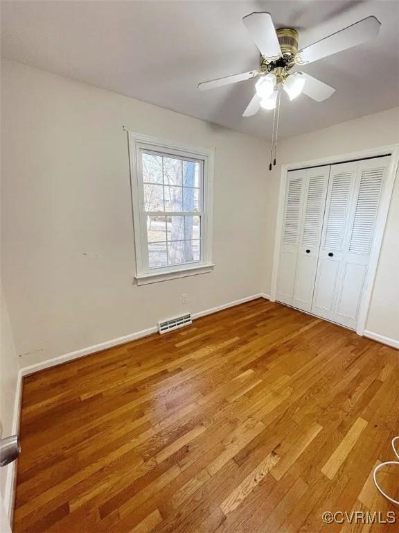 unfurnished bedroom featuring light wood finished floors, a closet, visible vents, and baseboards