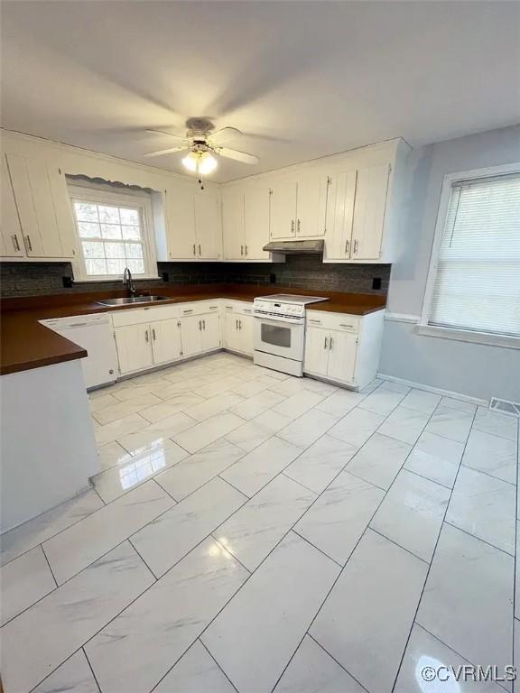 kitchen featuring white appliances, visible vents, dark countertops, under cabinet range hood, and a sink