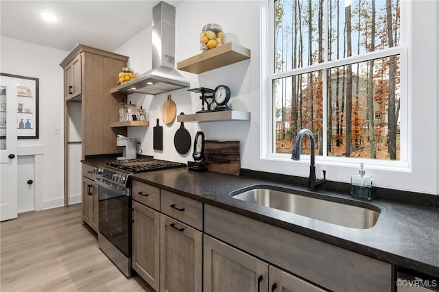 kitchen featuring a sink, open shelves, stainless steel gas range, and island exhaust hood