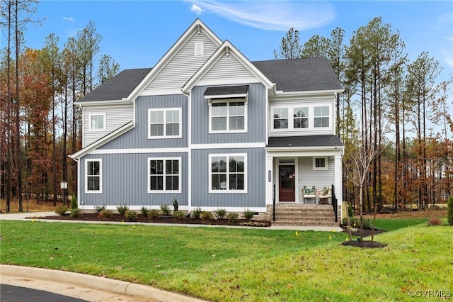 view of front of house featuring a porch, a front yard, and roof with shingles