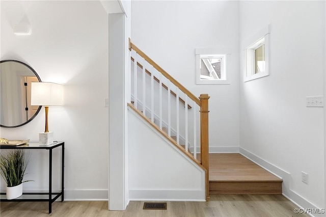 staircase featuring visible vents, baseboards, and wood finished floors