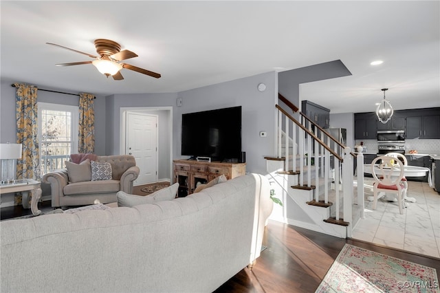 living area with ceiling fan, stairway, and recessed lighting