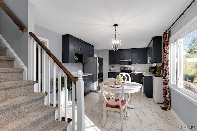 dining area featuring marble finish floor, stairs, baseboards, and a chandelier