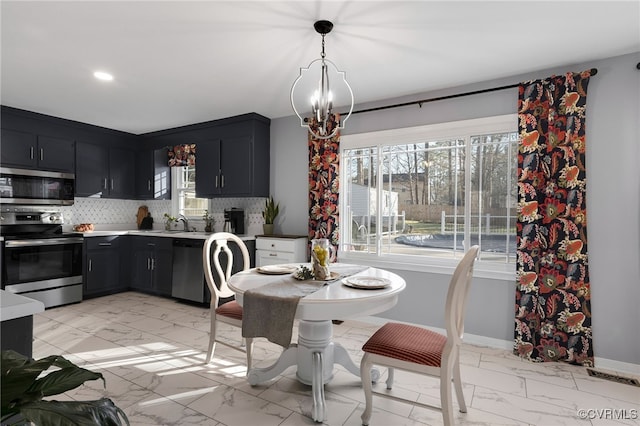 kitchen featuring marble finish floor, stainless steel appliances, and backsplash