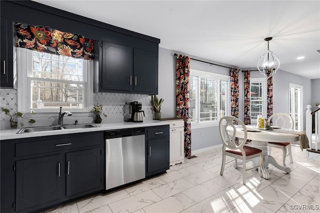 kitchen with backsplash, marble finish floor, light countertops, stainless steel dishwasher, and a sink