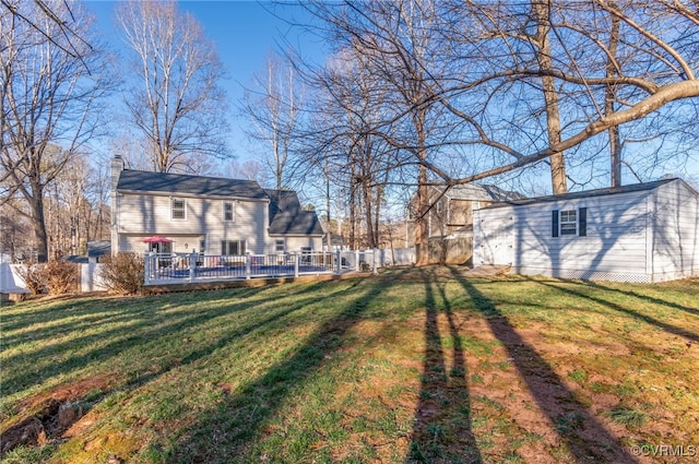 view of yard featuring fence and an outbuilding