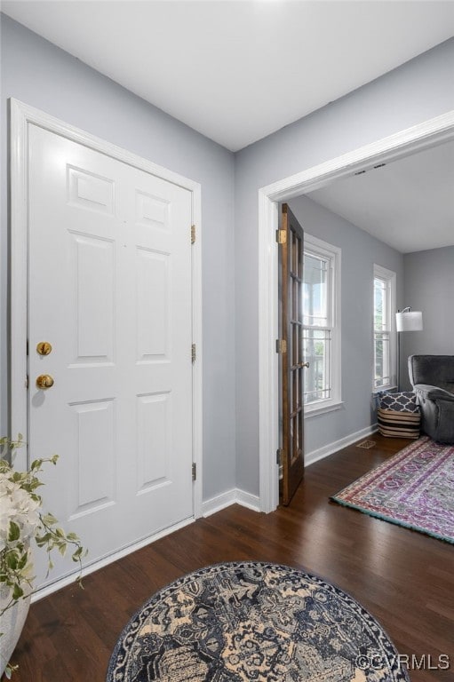 foyer entrance with baseboards and wood finished floors