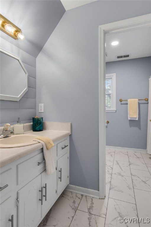 bathroom with marble finish floor, vanity, visible vents, and baseboards