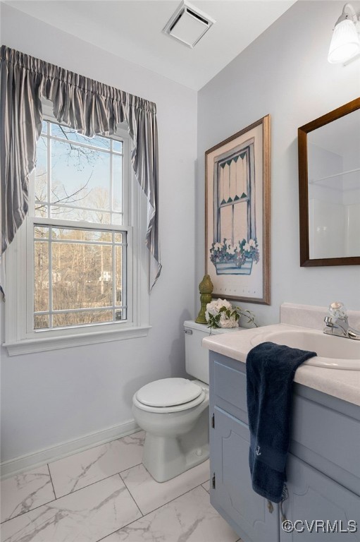 bathroom with visible vents, baseboards, toilet, marble finish floor, and vanity