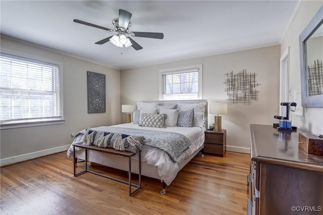 bedroom featuring baseboards, wood finished floors, a ceiling fan, and crown molding