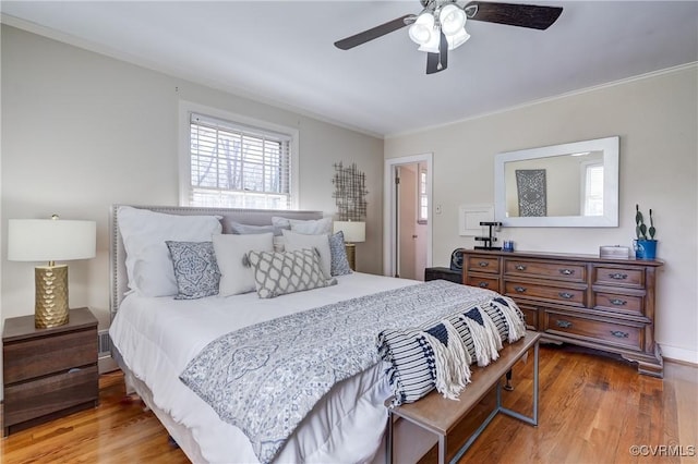 bedroom featuring wood finished floors, a ceiling fan, and crown molding