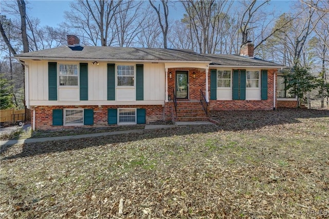 ranch-style house featuring board and batten siding, brick siding, and a chimney