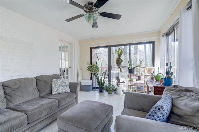 living area featuring ceiling fan, ornamental molding, and plenty of natural light