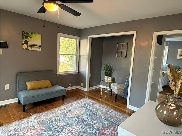 sitting room featuring wood finished floors, visible vents, and baseboards