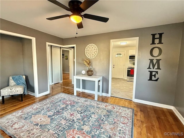 bedroom featuring ceiling fan, baseboards, and wood finished floors