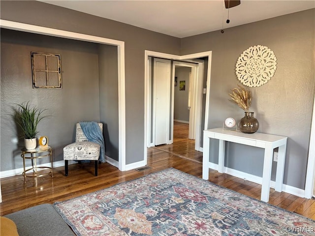 sitting room with visible vents, baseboards, and wood finished floors