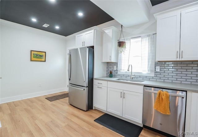 kitchen with stainless steel appliances, backsplash, a sink, and light countertops