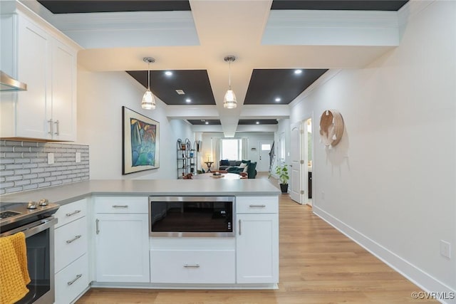 kitchen featuring stainless steel appliances, backsplash, white cabinets, coffered ceiling, and a peninsula