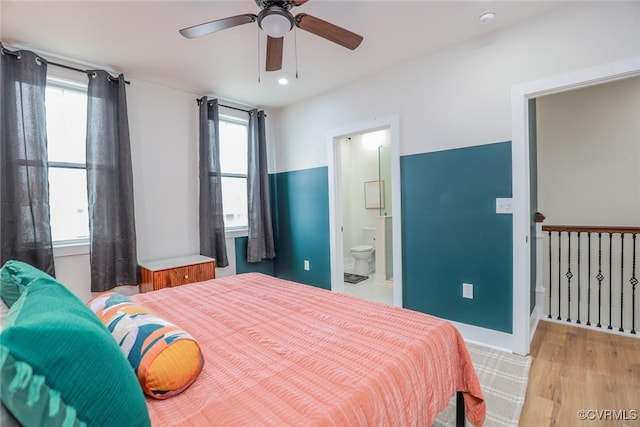 bedroom featuring ensuite bathroom, ceiling fan, and light wood-type flooring