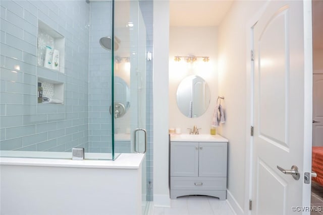 bathroom featuring a stall shower, vanity, and baseboards