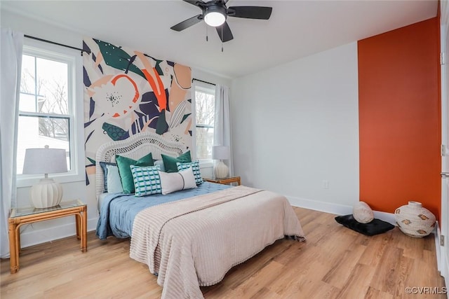 bedroom with wood finished floors, a ceiling fan, and baseboards