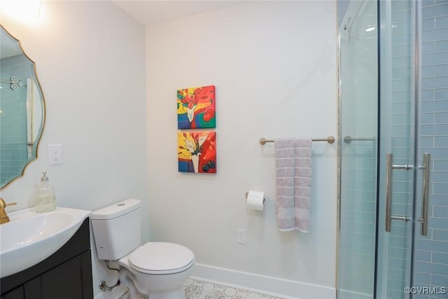 bathroom featuring toilet, a tile shower, vanity, and baseboards