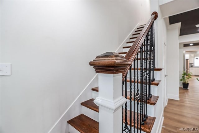 stairway featuring baseboards and wood finished floors