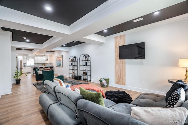 living room featuring baseboards, crown molding, and light wood-style floors