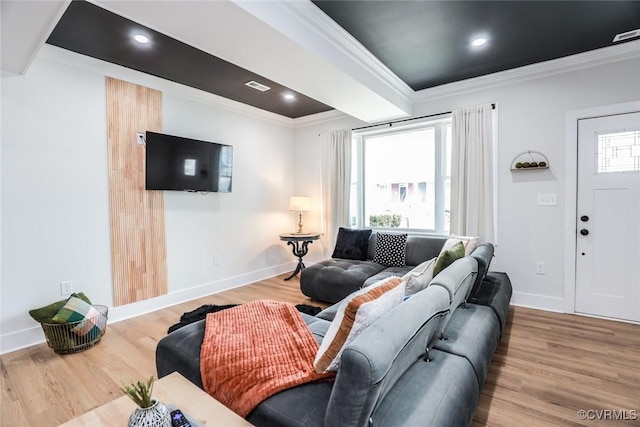 living room with ornamental molding, plenty of natural light, wood finished floors, and baseboards