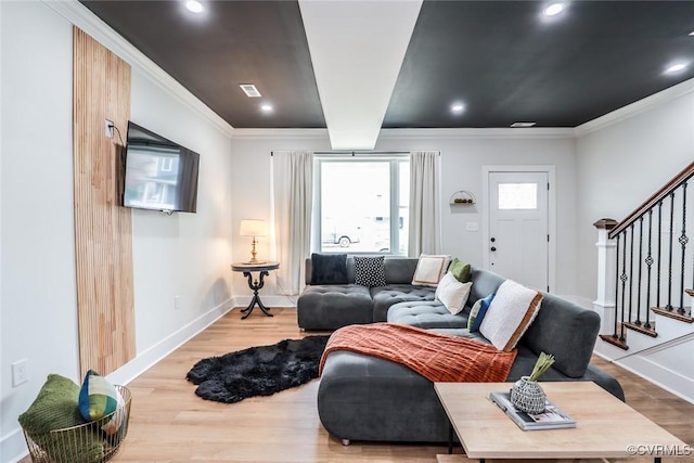 living room with stairs, baseboards, wood finished floors, and crown molding