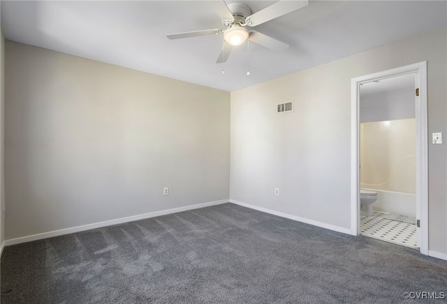 spare room with baseboards, visible vents, dark carpet, and a ceiling fan