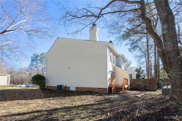 view of property exterior featuring crawl space, a chimney, fence, and central AC