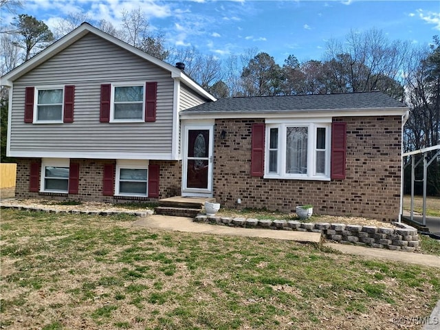 split level home with brick siding and a front lawn