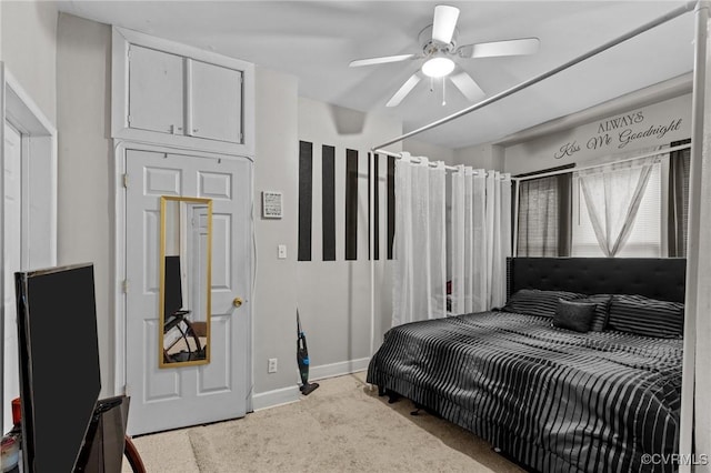 carpeted bedroom with baseboards and a ceiling fan