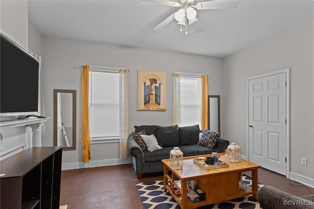 living room featuring baseboards, ceiling fan, and dark wood finished floors