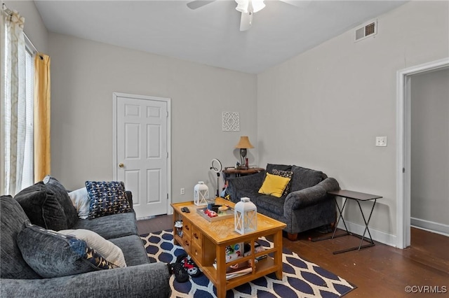 living area with visible vents, baseboards, a ceiling fan, and wood finished floors