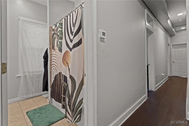 corridor featuring tile patterned flooring, recessed lighting, and baseboards