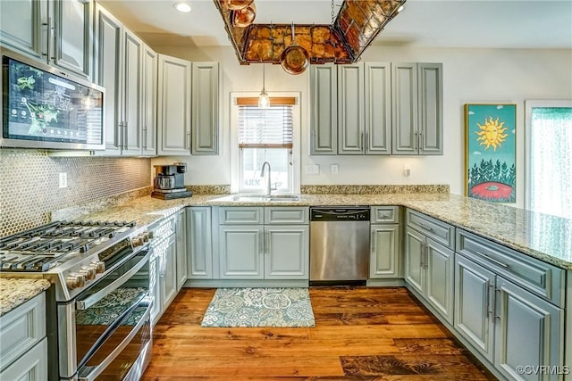 kitchen featuring a wealth of natural light, appliances with stainless steel finishes, dark wood-type flooring, and a sink