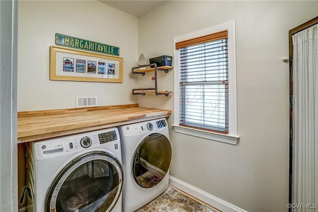 laundry room featuring baseboards, laundry area, visible vents, and washer and dryer