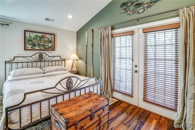 bedroom with french doors, visible vents, vaulted ceiling, wood finished floors, and access to outside