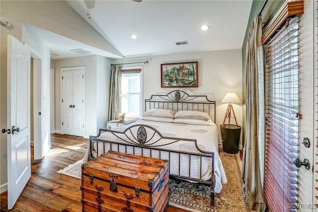 bedroom with lofted ceiling, visible vents, wood finished floors, and recessed lighting